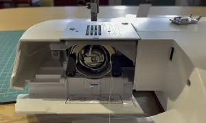 Zablokowane koło w maszynie do szycia. Widać mechanizm bębenka i igłę.
