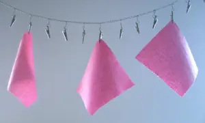 Trzy kawałki różowej flizeliny (czy fizeliny) wiszą na łańcuszku, przypięte klipsami.