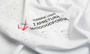 Biała tkanina z kropelkami wody i napisem "Tkanina light z apreturą wodoodporną". Idealna na deszczowe dni.