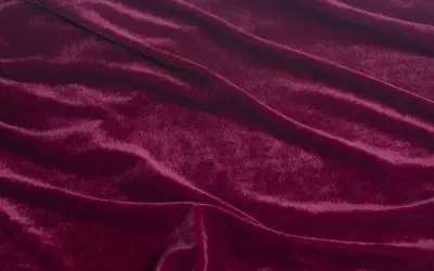 Głęboki, burgundowy rodzaj welwetu, miękko układający się w fałdy, odbijający światło.