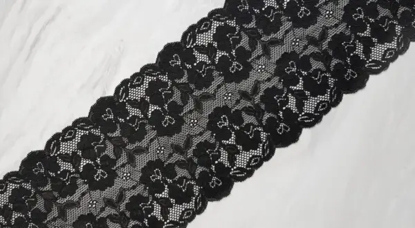 Elegancka koronka czarna z motywem kwiatowym, idealna do ozdobnych projektów.