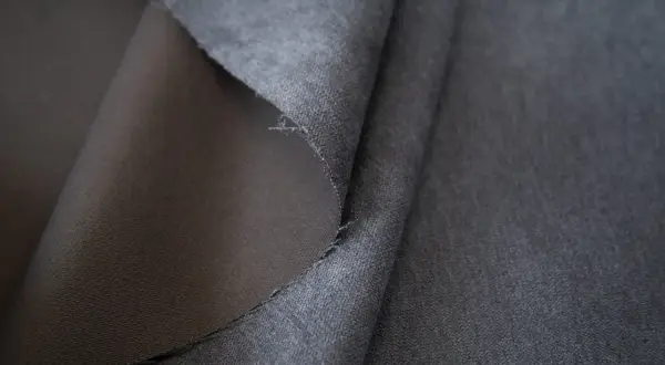 Szara tkanina soro, z jednej strony gładka, z drugiej lekko puszysta. Idealna na eleganckie ubrania.