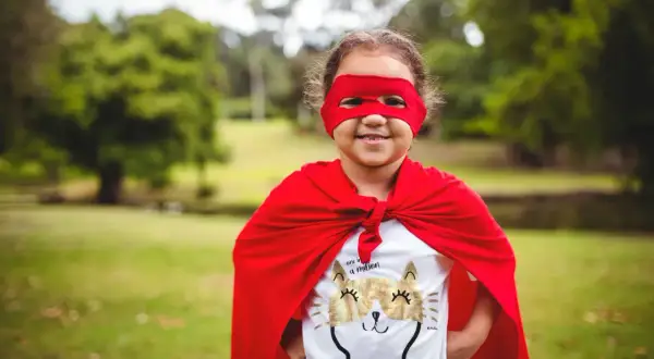 Mała superbohaterka w czerwonej pelerynie i masce, z kotkiem na koszulce. Świetny pomysł na strój karnawałowy!