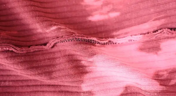 Różowa, prążkowana dzianina z efektem tie-dye. Elastyczna przędza do produkcji dzianin, widoczne szwy.