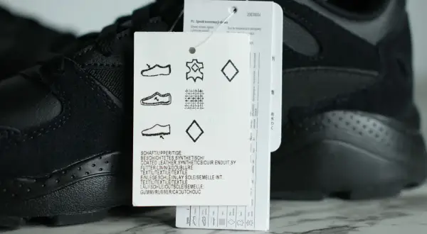 Czarny but sportowy z metką, na której widnieje symbol skóry naturalnej, wskazujący na wysoką jakość materiału.