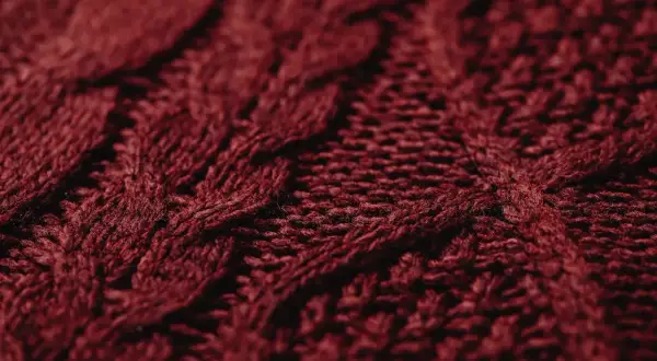 Ciemnoczerwona dzianina z warkoczowym splotem. To ciepłe, miękkie włókno, idealne na zimowe swetry.