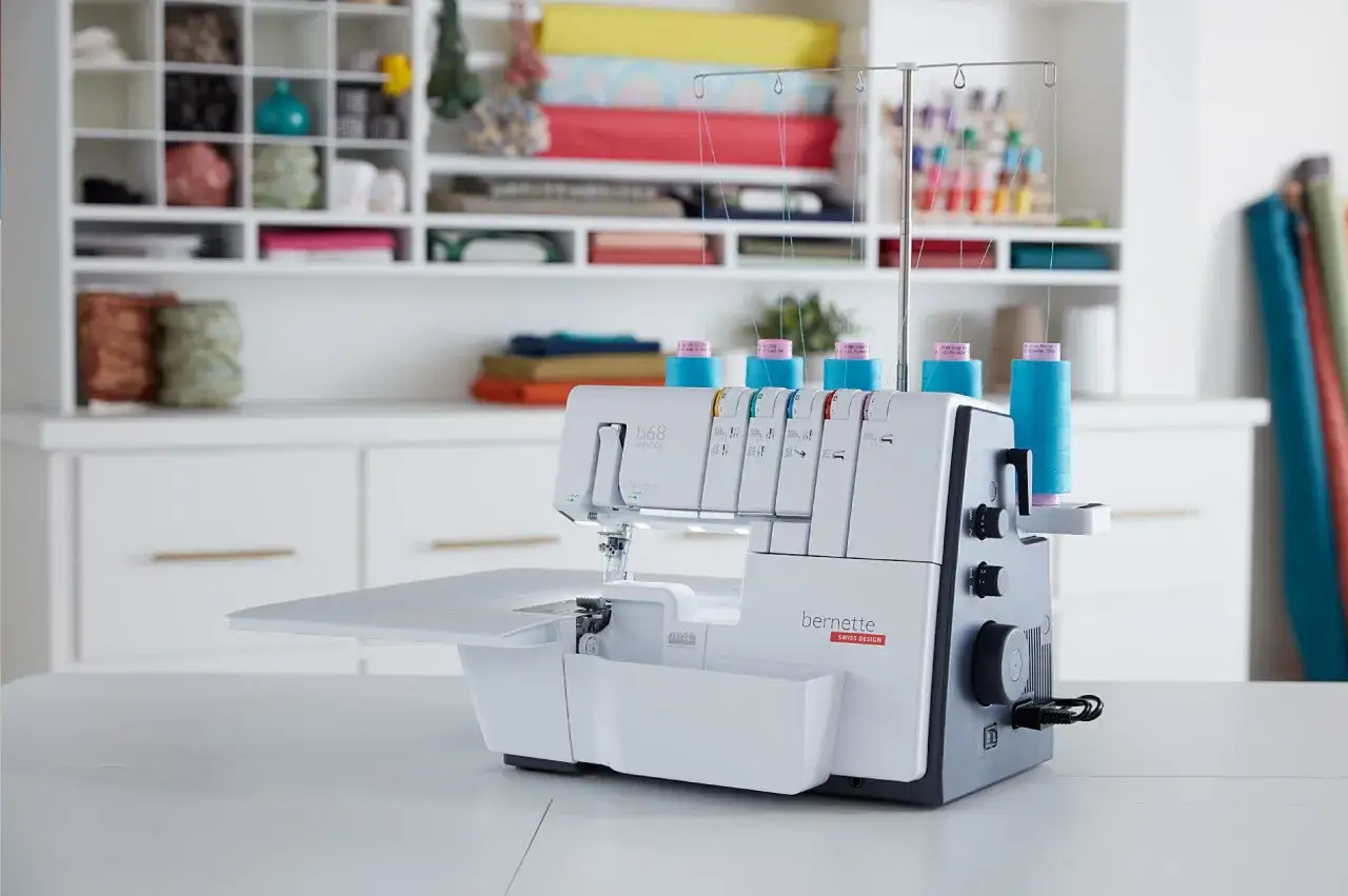 Owerlok przemysłowy Bernette z kolorowymi nićmi, gotowy do wymiany oleju i dalszego szycia.