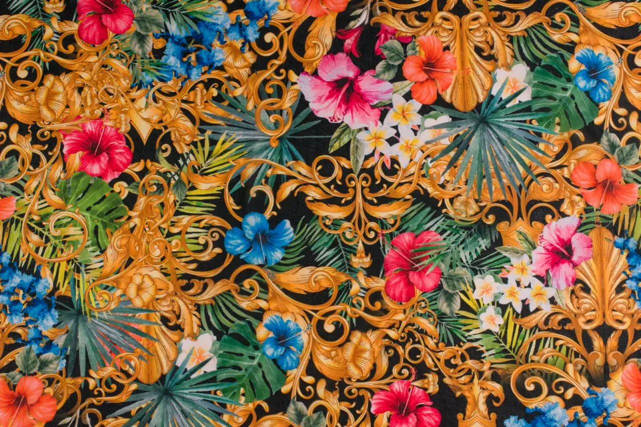 Tkanina w kwiaty tropikalne i złote ornamenty. Hibiskusy, plumerie i liście palmowe na czarnym tle.