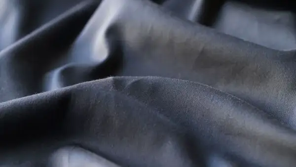 Miękkie, ciemne fałdy tkaniny, która jest zrobiona z poliestru.